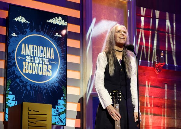 A musician speaks onstage after having won an award