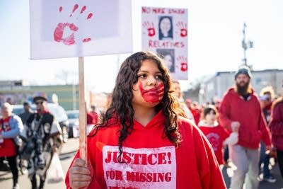 A girl holds a sign