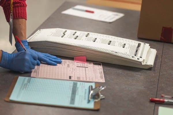 A poll worker handles ballots for the midterm election, in the presence of observers from both Democrat and Republican parties, at the Maricopa County Tabulation and Elections Center (MCTEC) in Phoenix, Arizona, on October 25, 2022.