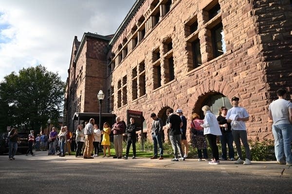 A crowd waits outside a building