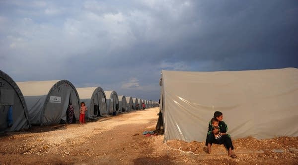 Kurdish refugee boys from the Syrian town of Kobani sit near their family tent in a camp in the southeastern town of Suruc, Sanliurfa.