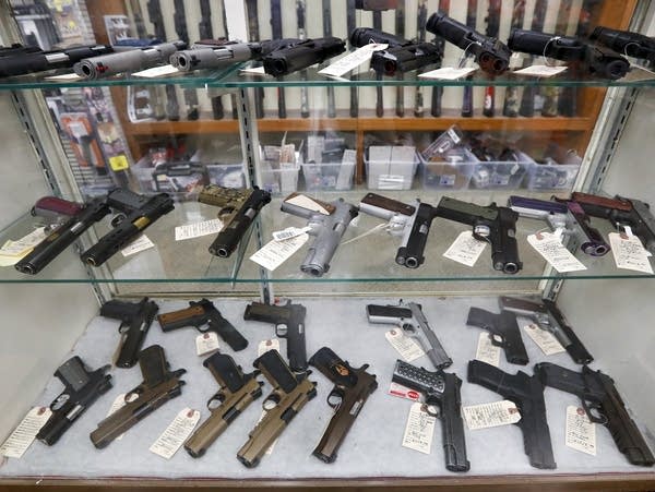 A display case shows a number of handguns.