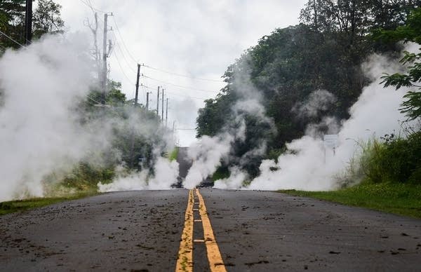 Steam rises from a fissure on a road.