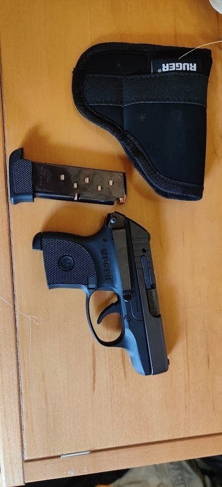 a gun, holster and magazine sit on a table