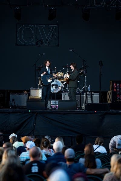 Two musicians performing on an outdoor stage