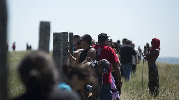 Protesters look over a fence at the construction.