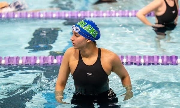 A student races in a swim meet.