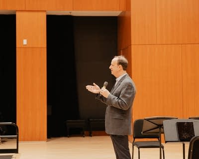 A man speaks to an audience in an auditorium