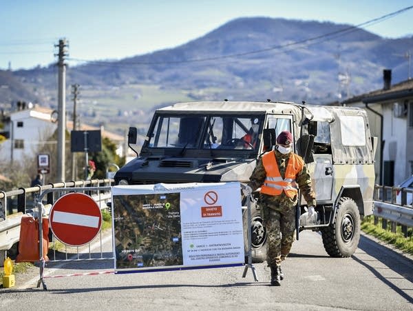 An Italian soldier blocks off a road