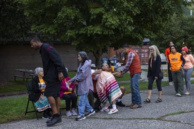 People line up to hug and shake hands