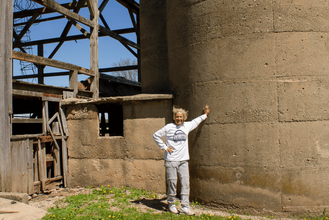 A woman leans on a silo