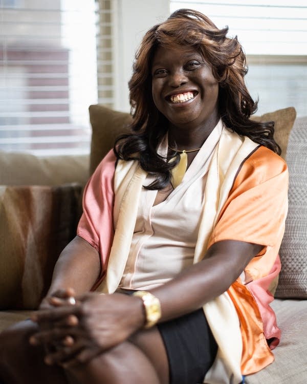 A Black woman smiles for a portrait