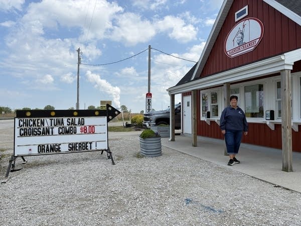 Tonia Tice stands in front of an ice cream stand that looks like a classic red and white barn.