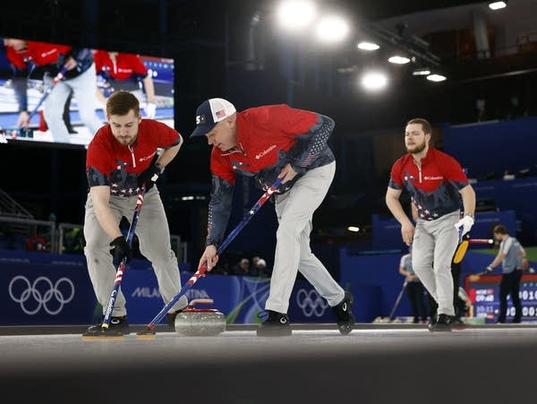 Men's curlers compete in an Olympic match