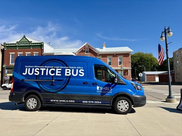 A blue cargo van with the Justice Bus written across