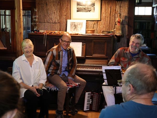 three seated people smile broadly