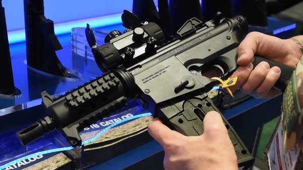 A convention attendee looks at a Mossberg International pistol at the 2016 Shooting, Hunting, and Outdoor Trade Show at the Sands Expo Convention Center in Las Vegas.