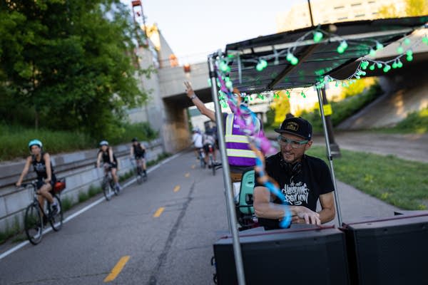 A man DJs from a bike trailer