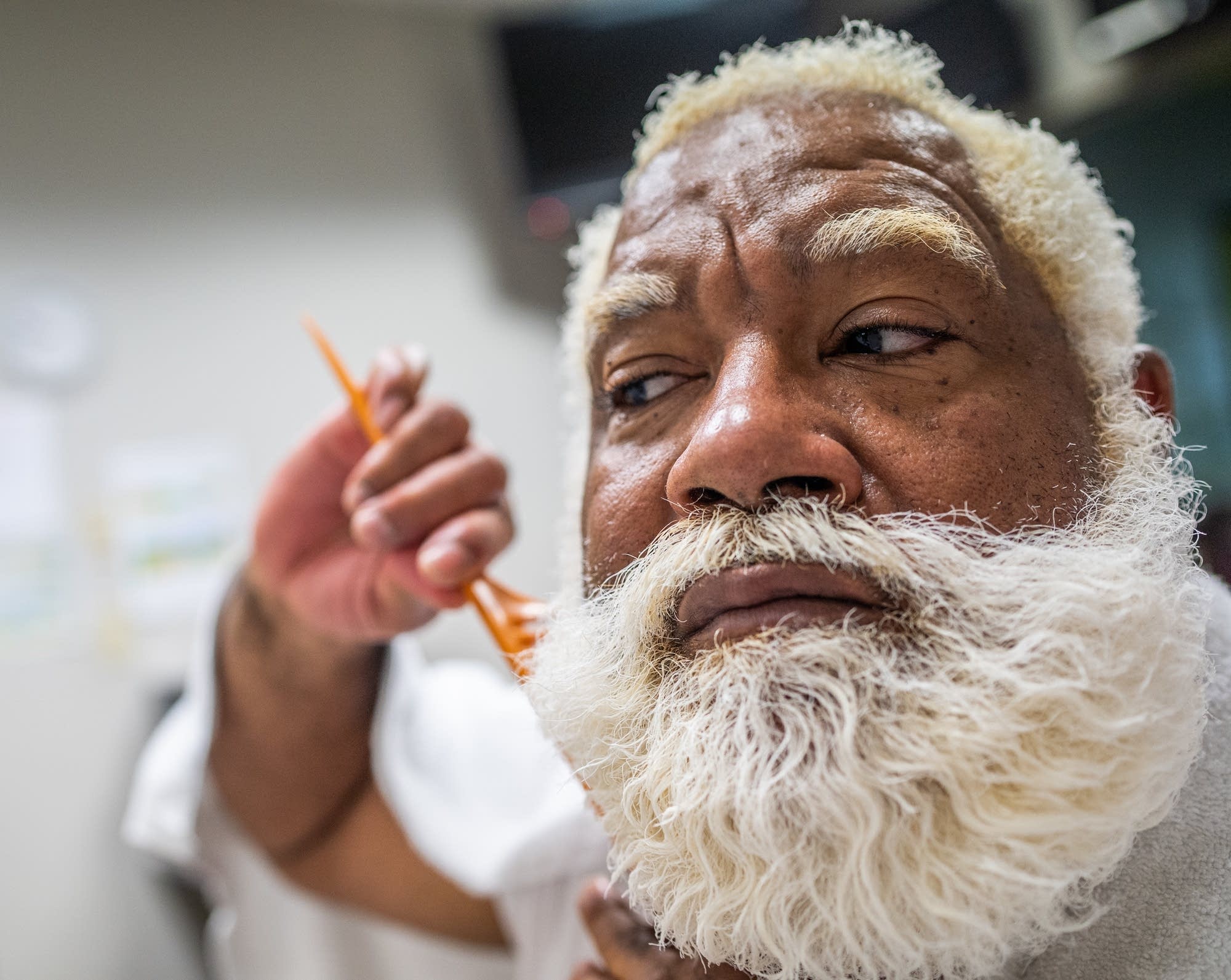 Santa Larry Jefferson combs his beard as he prepares for photo shoots.