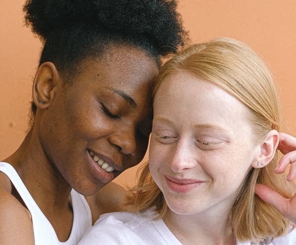 Two women touching their foreheads together