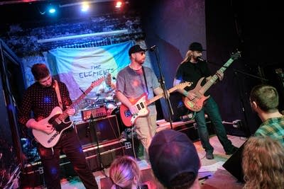 Three musicians performing onstage