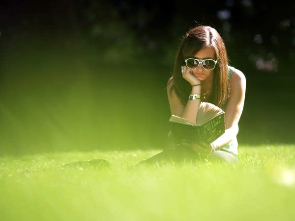 A woman reads in Victoria Tower Gardens