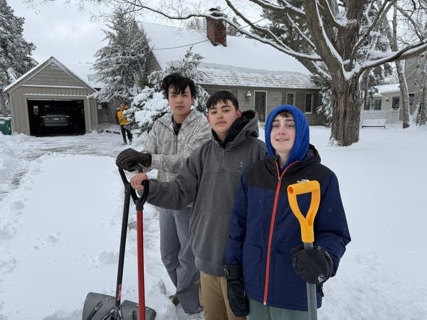 (From left to right) Joseph Teng, 13, Armando Velasquez, 13, and Alton Ayres, 13, help shovel snow after a sleepover Mar. 15, 2026.  