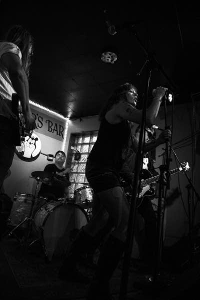 A rock band performing inside a small bar venue