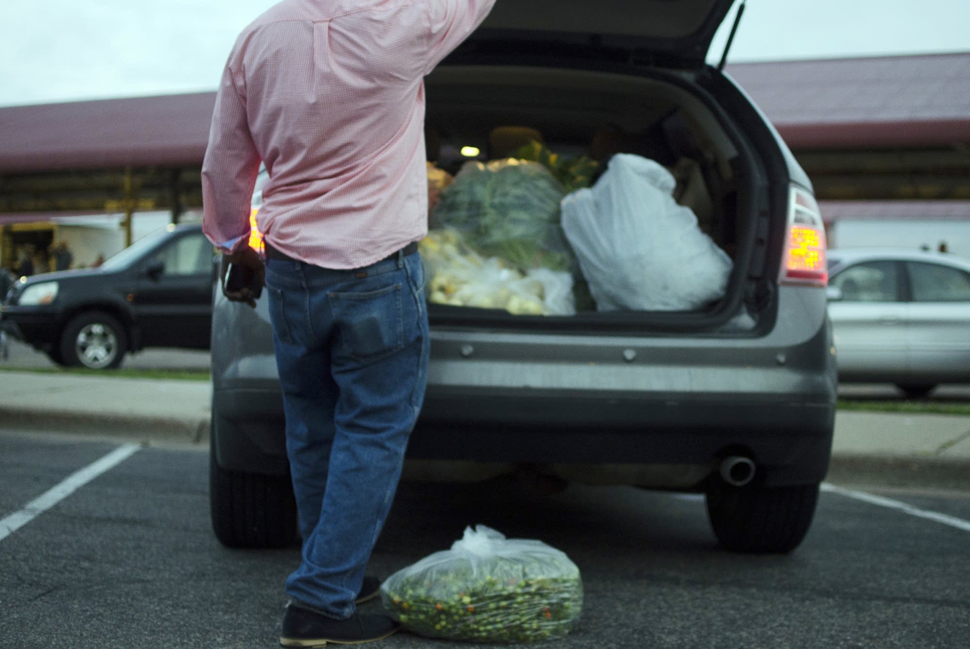 Blama kollie puts vegetables into his car.