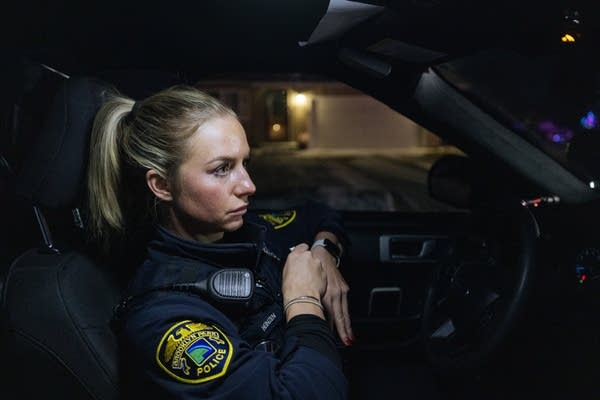 A female officer sits in a car