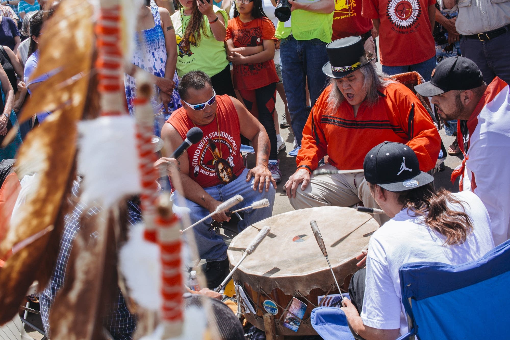 Dakota men play a song on drums.