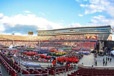 Wide shot of a stadium full of people at sunset.