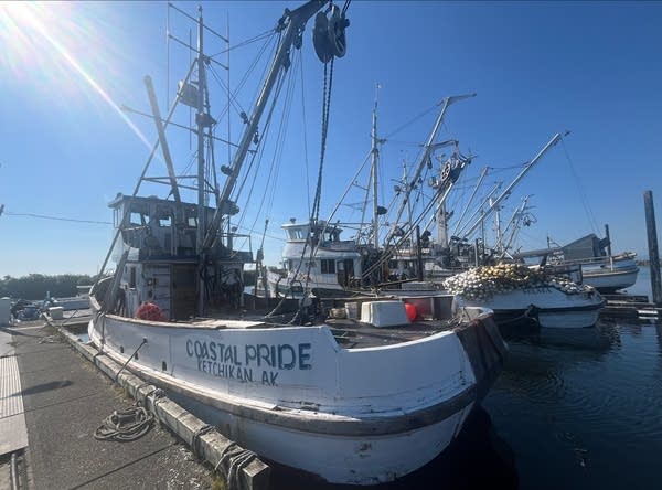 Of several boats in a harbor, the one in the foreground says Coastal Pride.