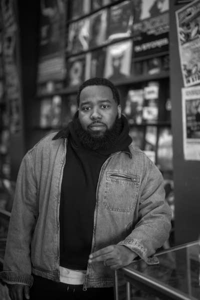 A man poses for a photo inside a record store