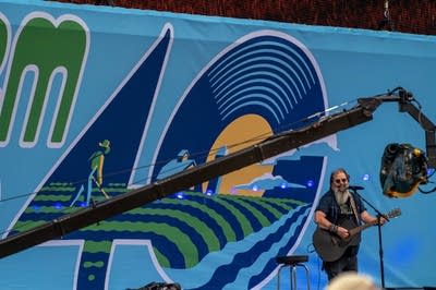 steve earle performing on stage with an acoustic guitar
