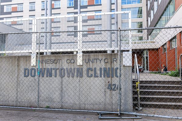 Construction fencing surrounds the entrance to the MN Community Care Downtown Clinic