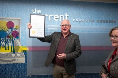 Minnesota Gov. Tim Walz holds up a proclamation at The Current.
