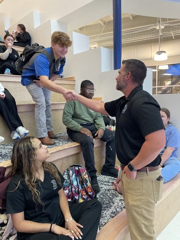 A man shakes hands with a student.