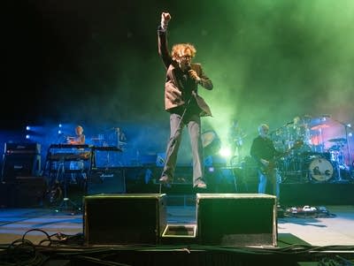 Jarvis Cocker of Pulp pumps his fist while standing on platforms as he performs at Armory.