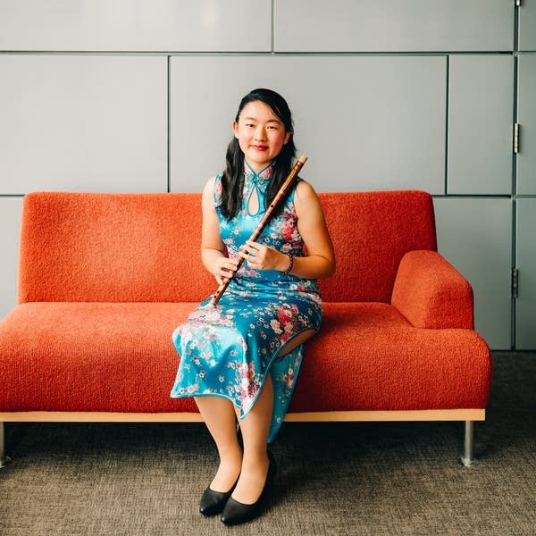 Poster Ammy Lin on orange couch with dizi