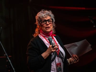 A woman holds a microphone.