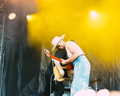 Devon Gilfillian performing with a guitar on stage