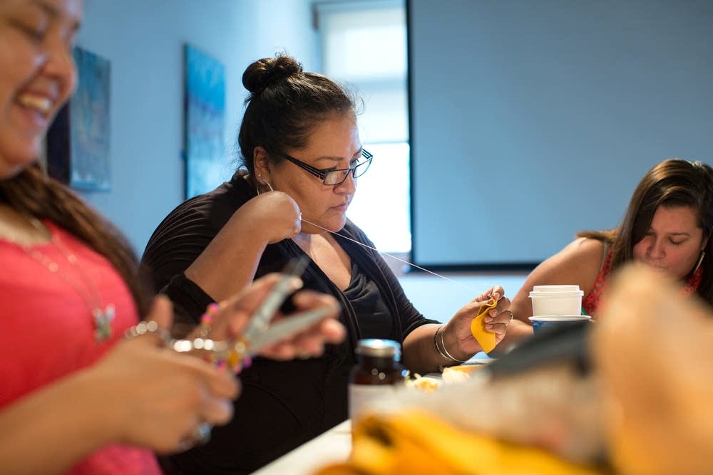 Volunteers hand sew baby moccasins