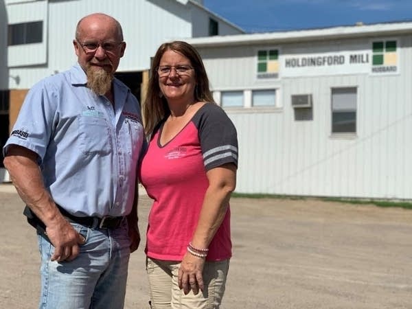 two people pose in front of mill