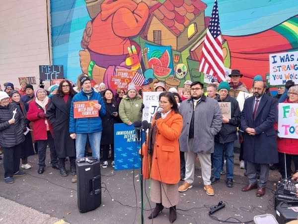 Speakers address a crowd at a community vigil