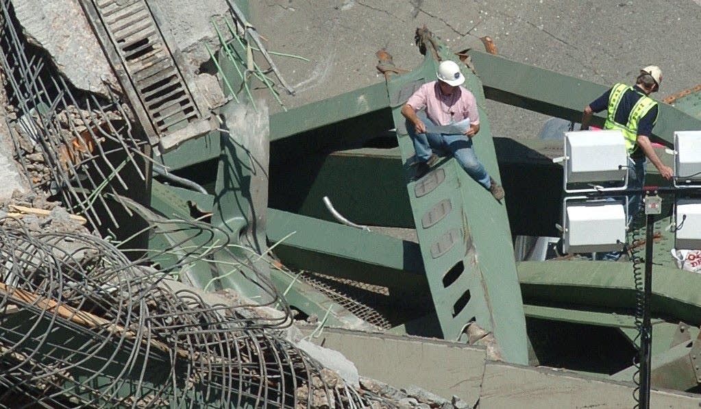 Investigators inspect the collapsed wreckage of the I-35W freeway bridge.