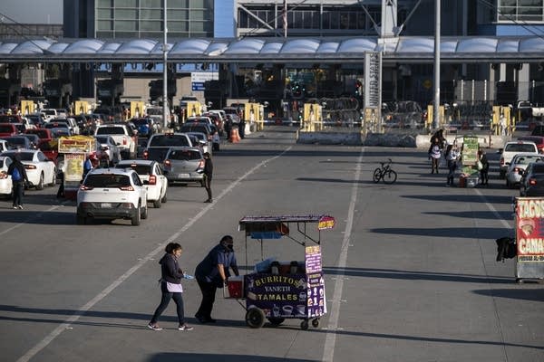 Street vendors sell food wearing face masks as a preventive measure to avoid the spread of COVID-19 coronavirus, at San Ysidro crossing in Tijuana, Baja California state, Mexico, on April 23, 2020, on the US-Mexico border. - US President Donald Trump partially blocked immigration to the United States "to protect American workers" from the economic shock of the coronavirus, as the United Nations warned the world was facing "a humanitarian catastrophe". (Photo by Guillermo Arias / AFP) (Photo by GUILLERMO ARIAS/AFP via Getty Images)