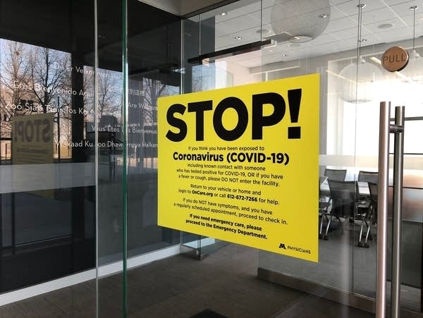 A sign on a door of a clinic reads "Stop!"