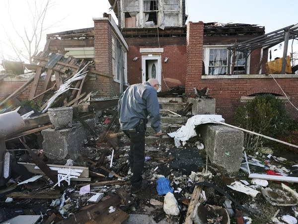 A man walks near his tornado-damaged home