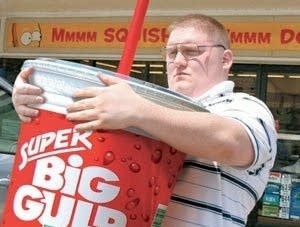 Large man wrapping arms around HUGE "Big Gulp" cup
